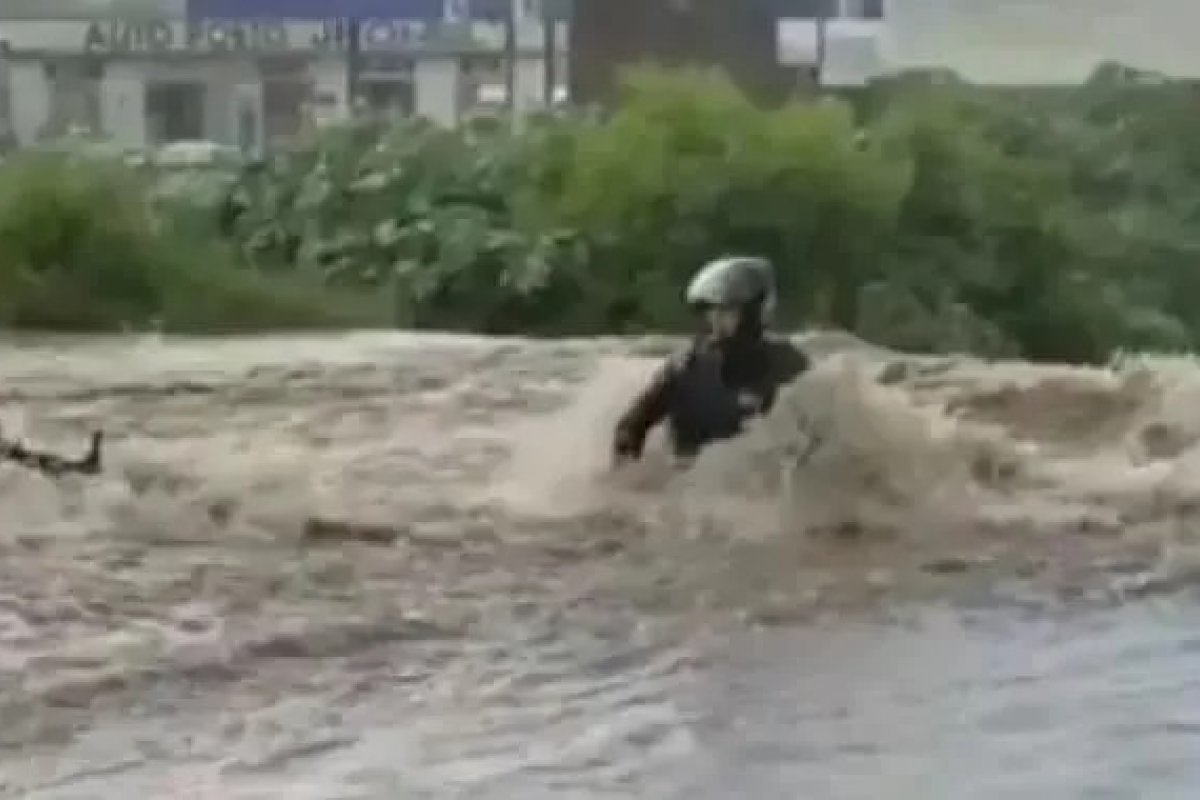 Mulher tenta atravessar enxurrada de moto e é arrastada pela correnteza