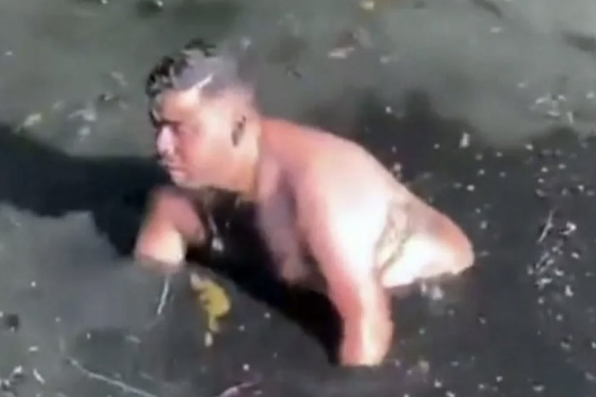 Homem mergulha em esgoto para resgatar celular no Rio de Janeiro