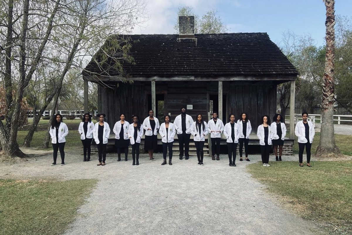 Estudantes de medicina tiram foto em frente a uma antiga fazenda de escravos
