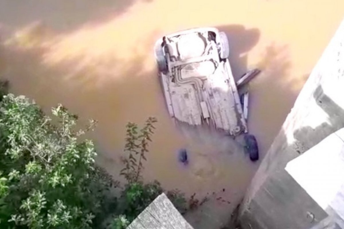 Carro cai de pista com cinco metros de altura e fica submerso em um rio no sul da Bahia