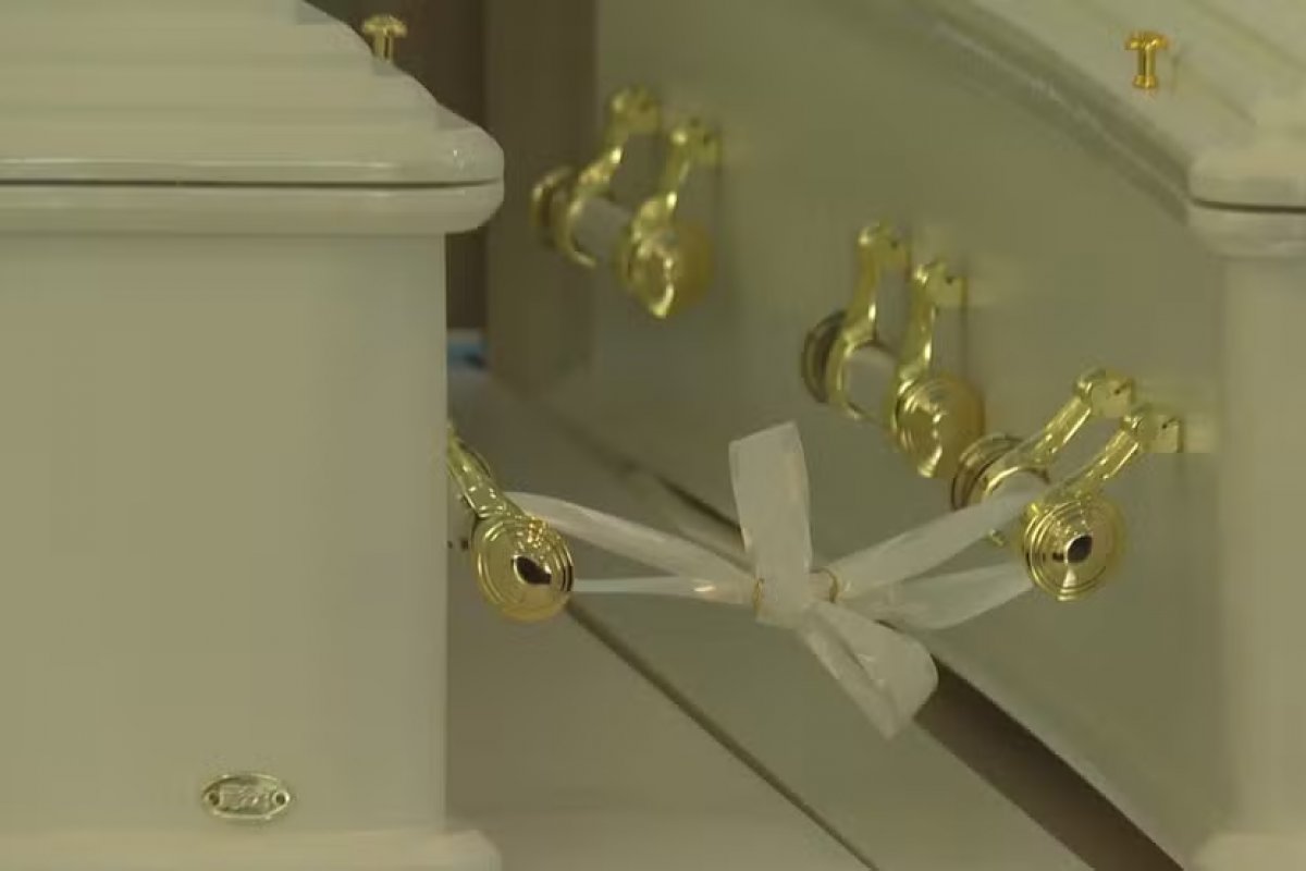 Casal morto em queda de avião em SP é homenageado com fita branca e alianças unindo caixões