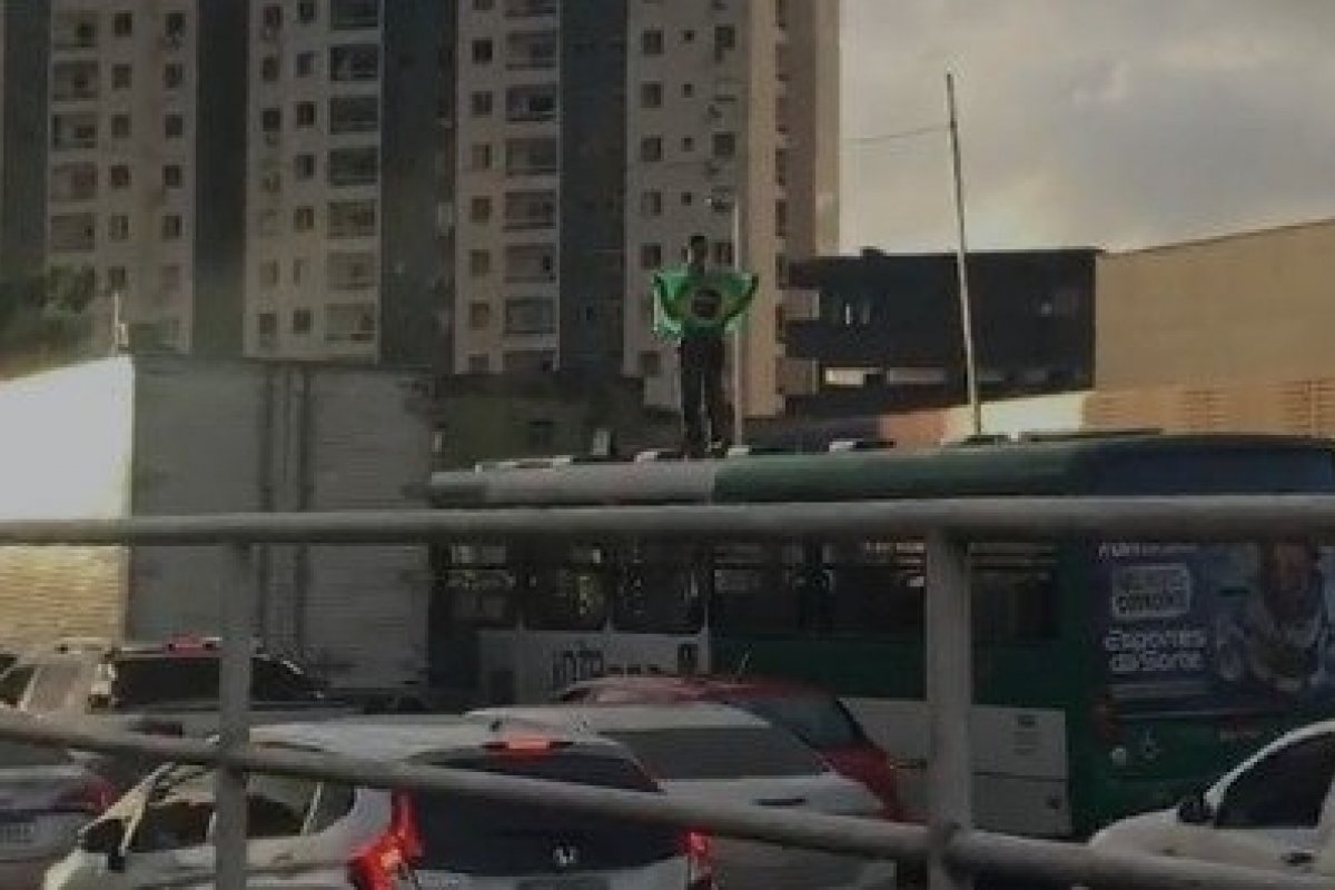 Vídeo: Motorista 'surta' e sobe em cima de ônibus com bandeira do Brasil