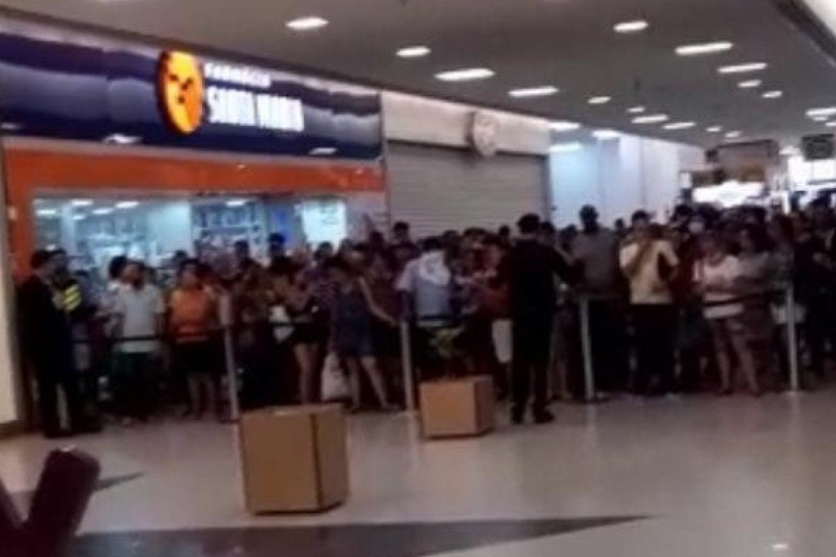 Multidão se aglomera para entrar em shopping