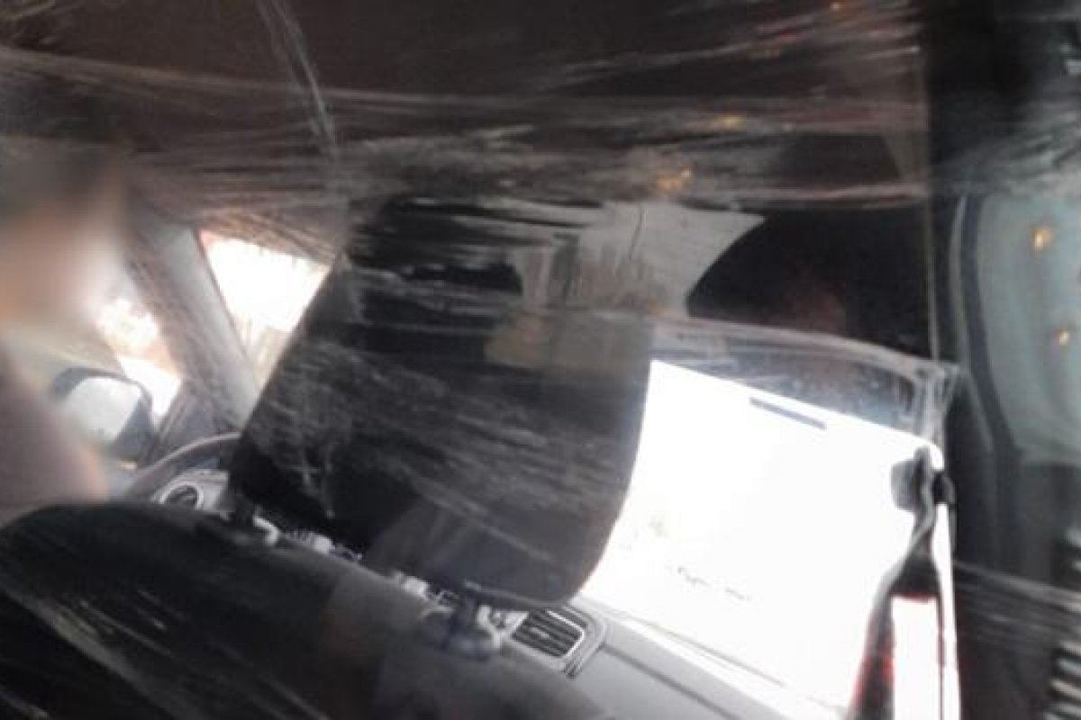 Motorista de aplicativo coloca plástico filme para se proteger da infecção do coronavírus