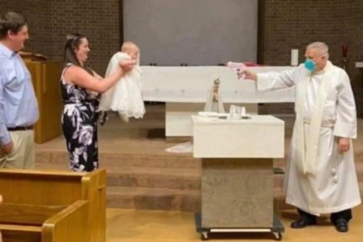 Padre batiza criança com pistola de água benta para manter o distanciamento