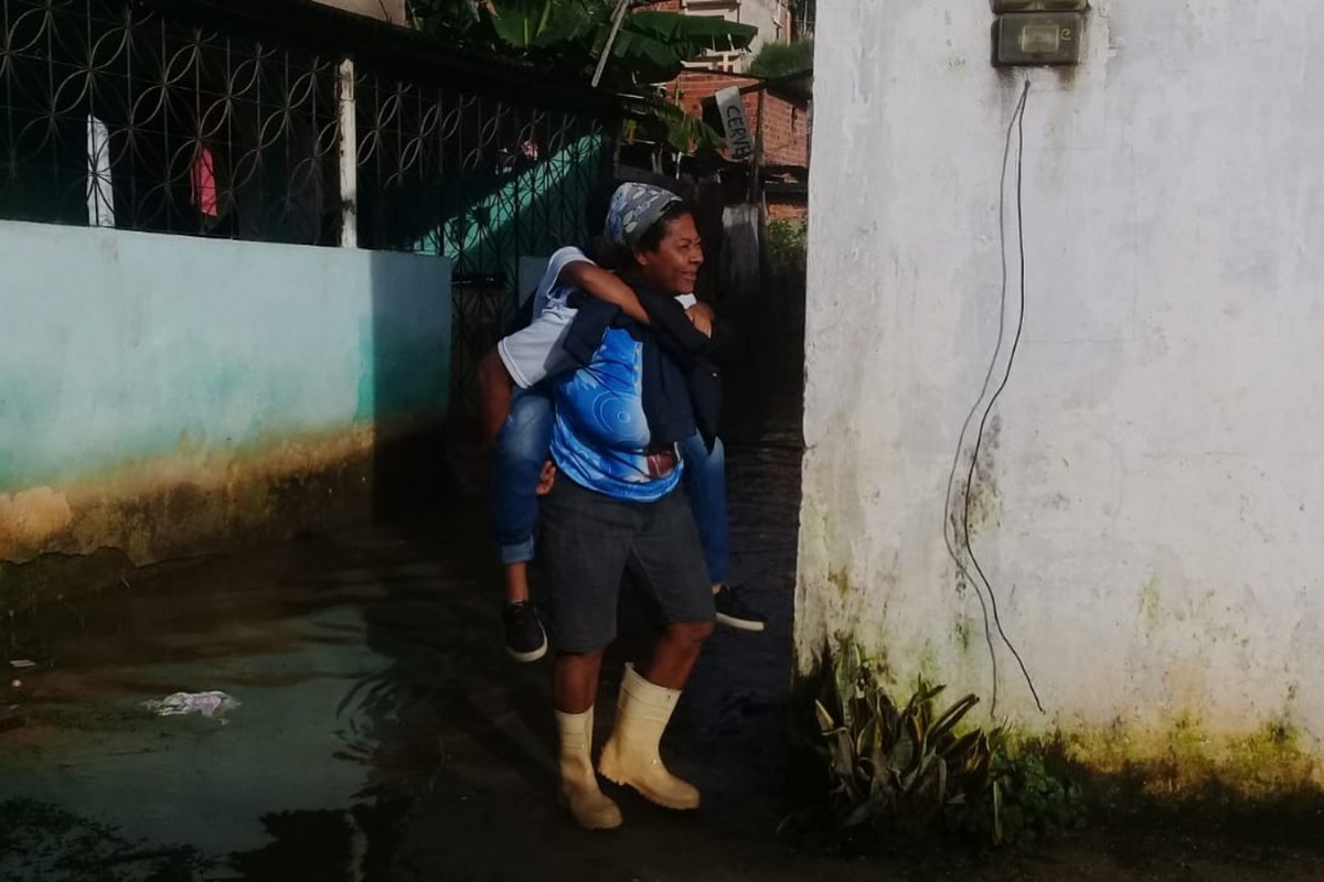 Bairro de Salvador alaga e mães carregam filhos nas costas
