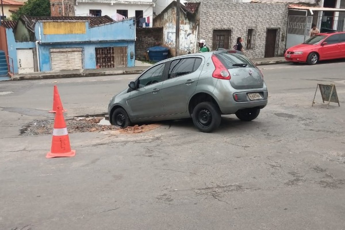 Carro cai e fica preso em buraco causado por vazamento de tubulação em Pernambués