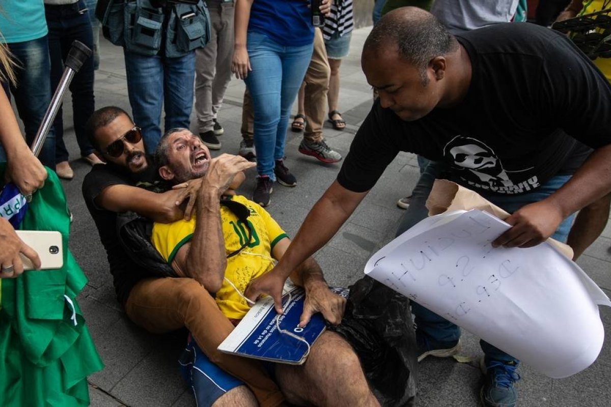 Apoiadores de Daniel Silveira agridem manifestante com placa de Marielle Franco na porta da PF