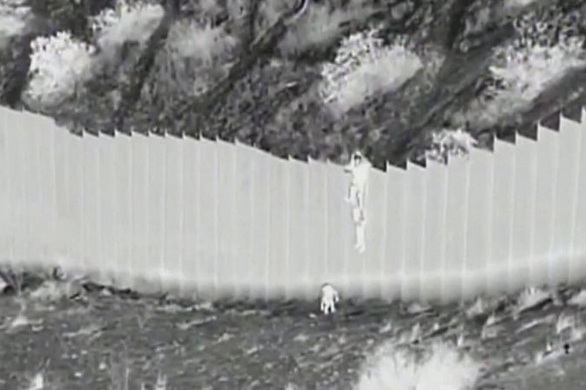 Duas crianças são jogadas sobre cerca na fronteira entre México e EUA