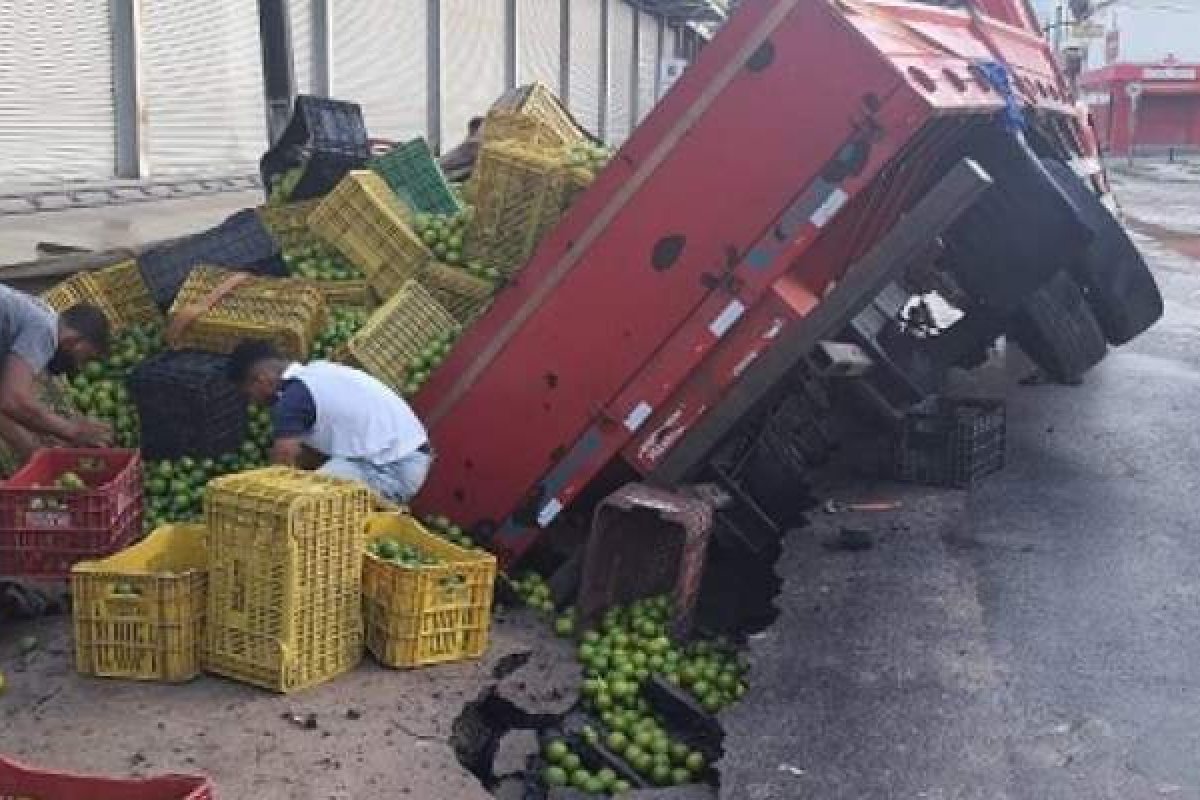 Caminhão com laranjas fica preso em buraco após piso ceder, em Feira de Santana