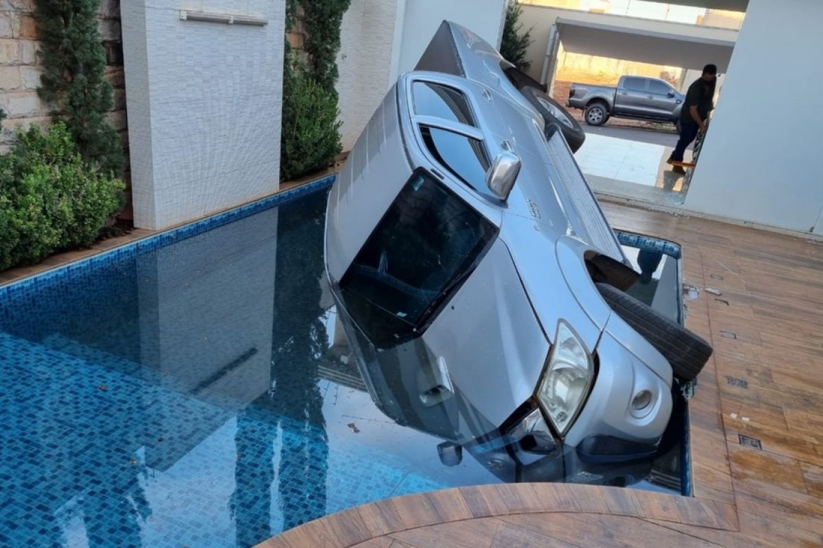 Motorista acelera caminhonete, quebra vidro da garagem e cai na piscina de casa
