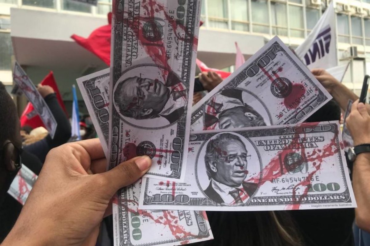 Manifestantes jogam “dólares” com o rosto de Guedes em frente ao Ministério da Economia